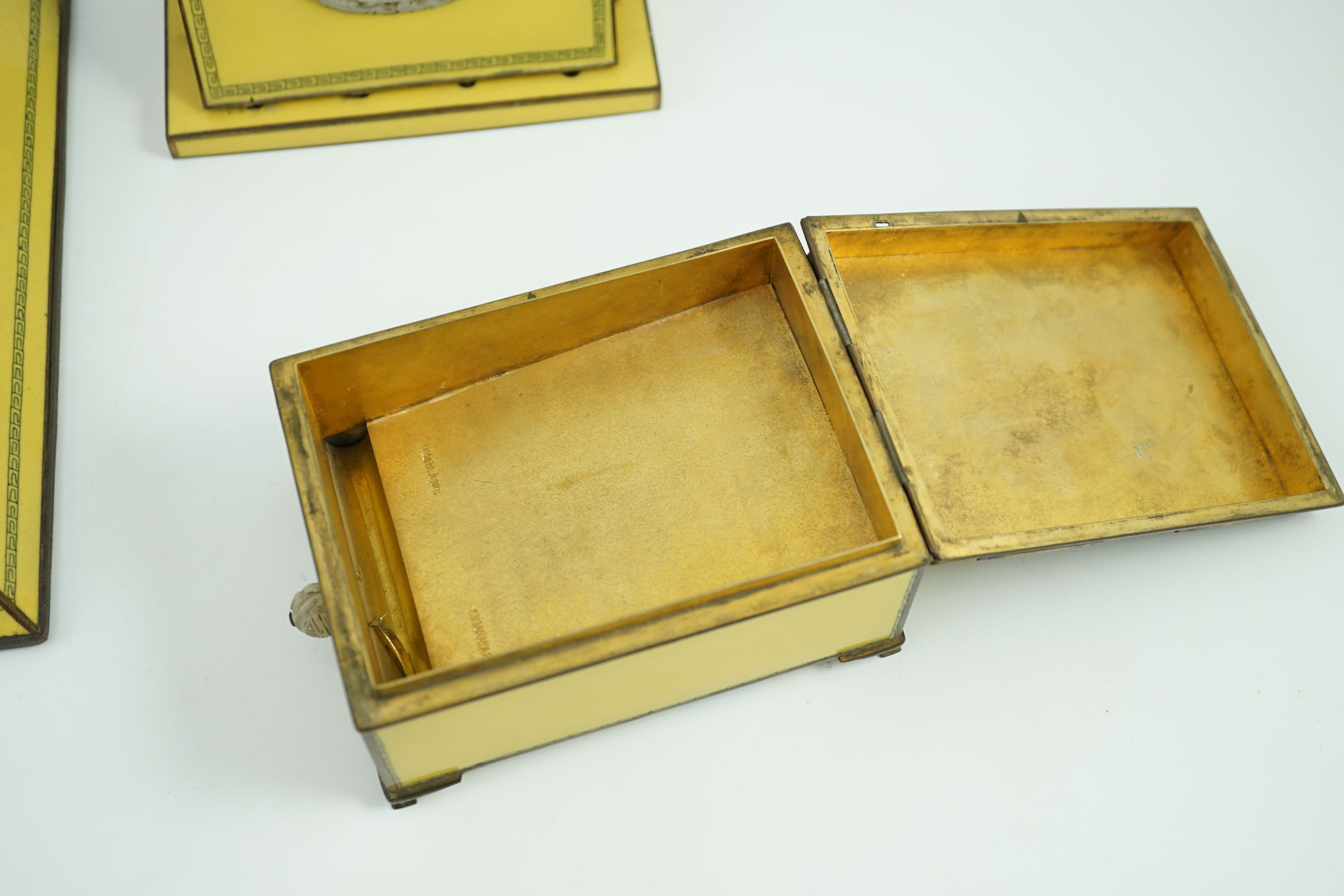 A Japanese cloisonné enamel desk set, 1920s, mounted with two Chinese Qing dynasty pale celadon jade plaques, retailed by Yamanaka & Co., Inkstand 31cm wide